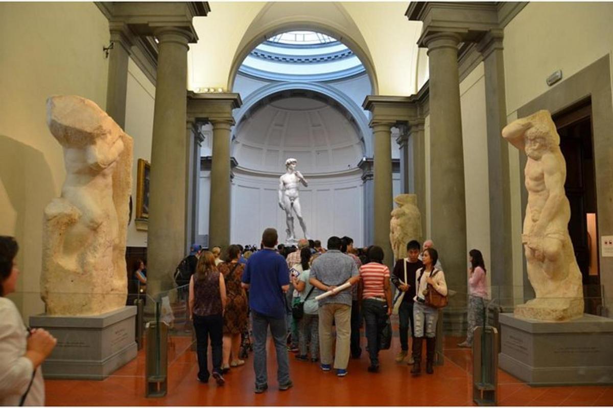 a group of people looking at statues in a museum