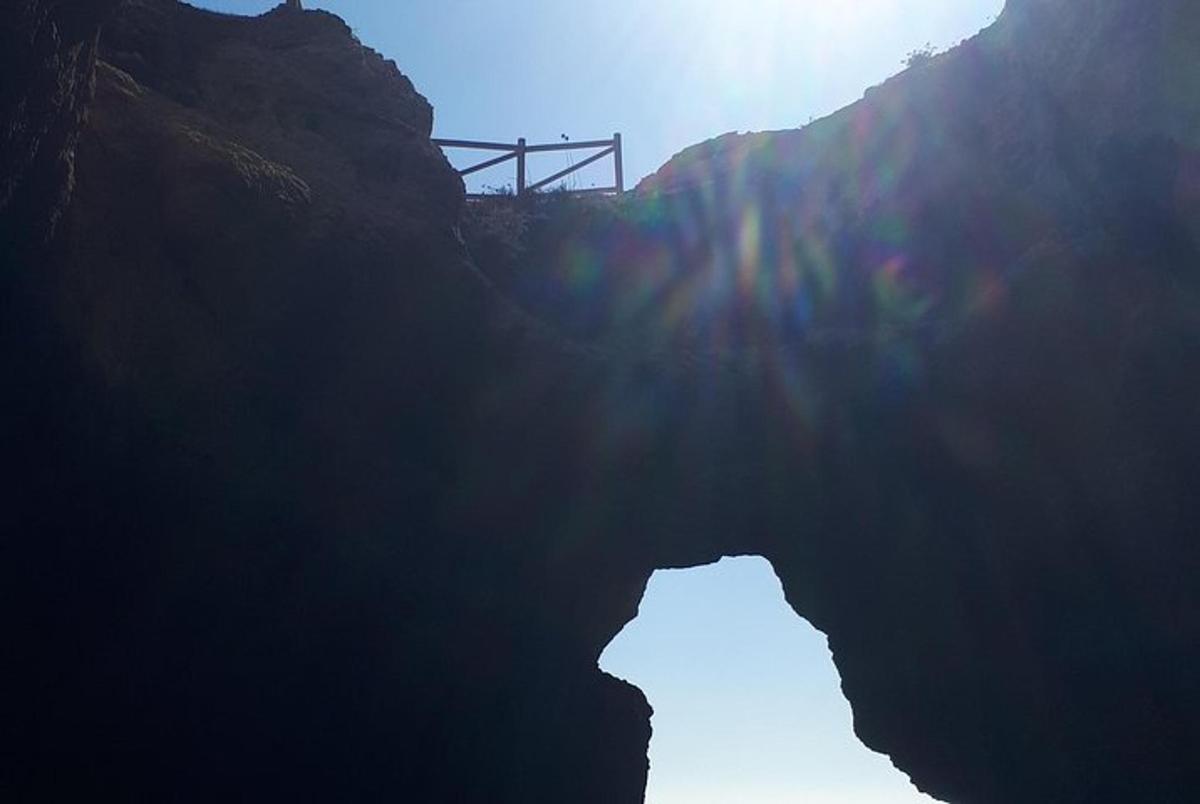 pemandangan gua dengan matahari bersinar di atas gunung