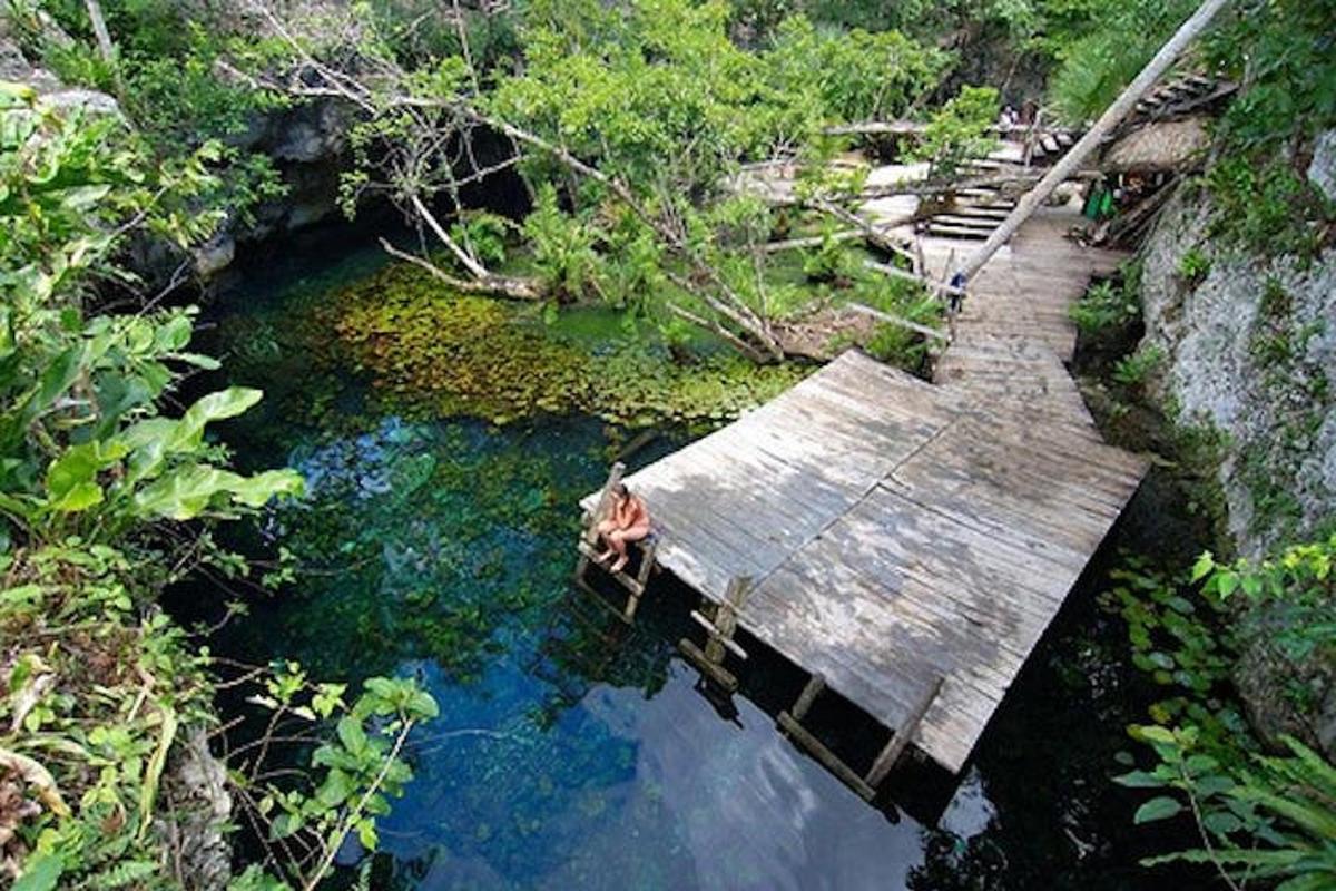 seseorang yang duduk di atas jambatan kayu di dalam air