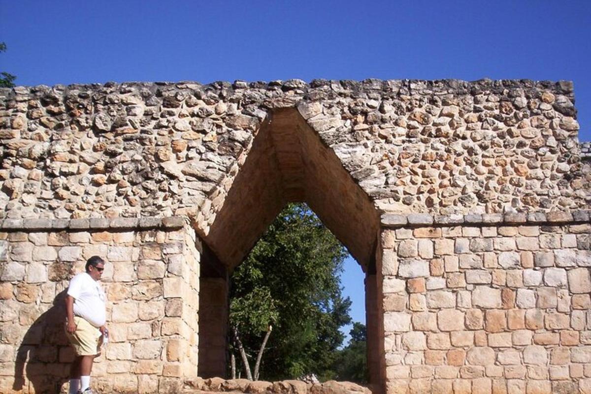 un uomo in piedi davanti a un muro di pietra