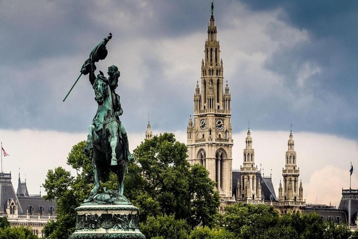 una statua di fronte a un edificio con una torre dell'orologio