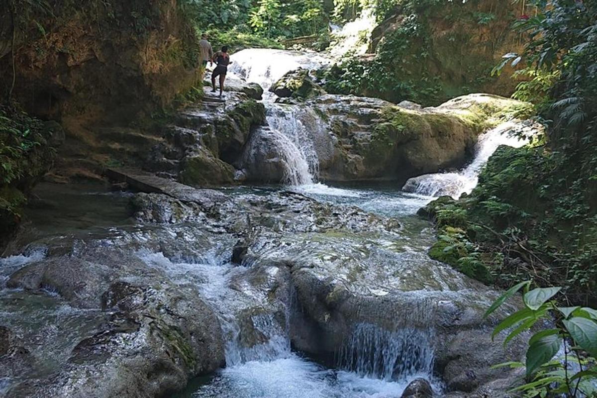 uma pessoa está parada em uma cachoeira em um rio