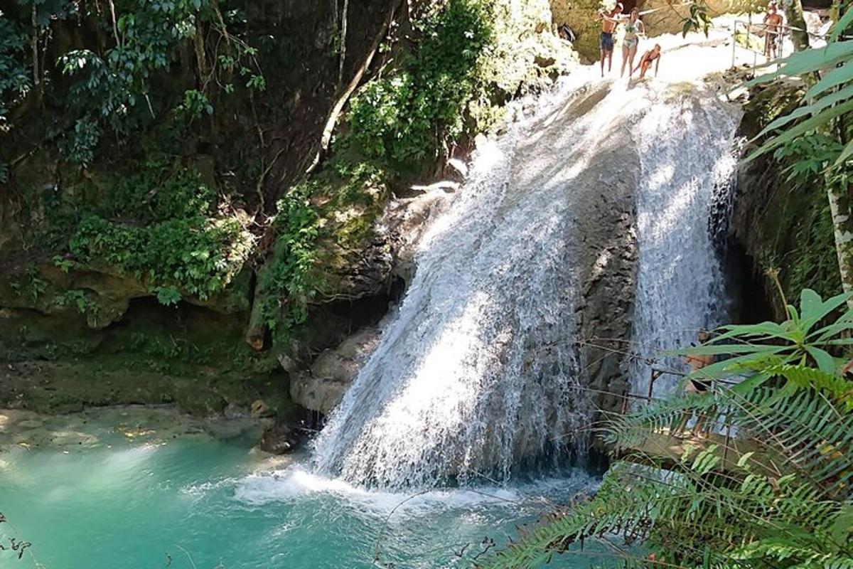 uma cachoeira com pessoas em pé no topo dela