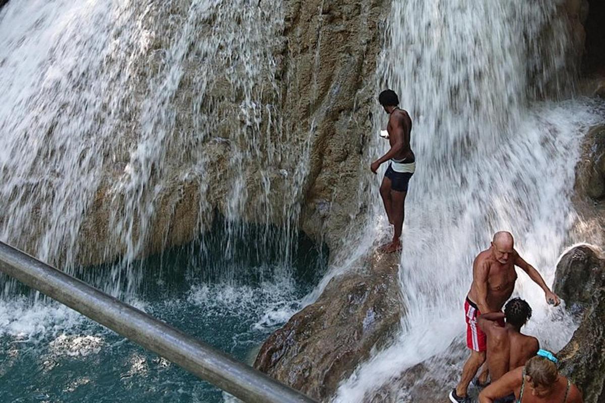 um grupo de homens em pé no topo de uma cachoeira