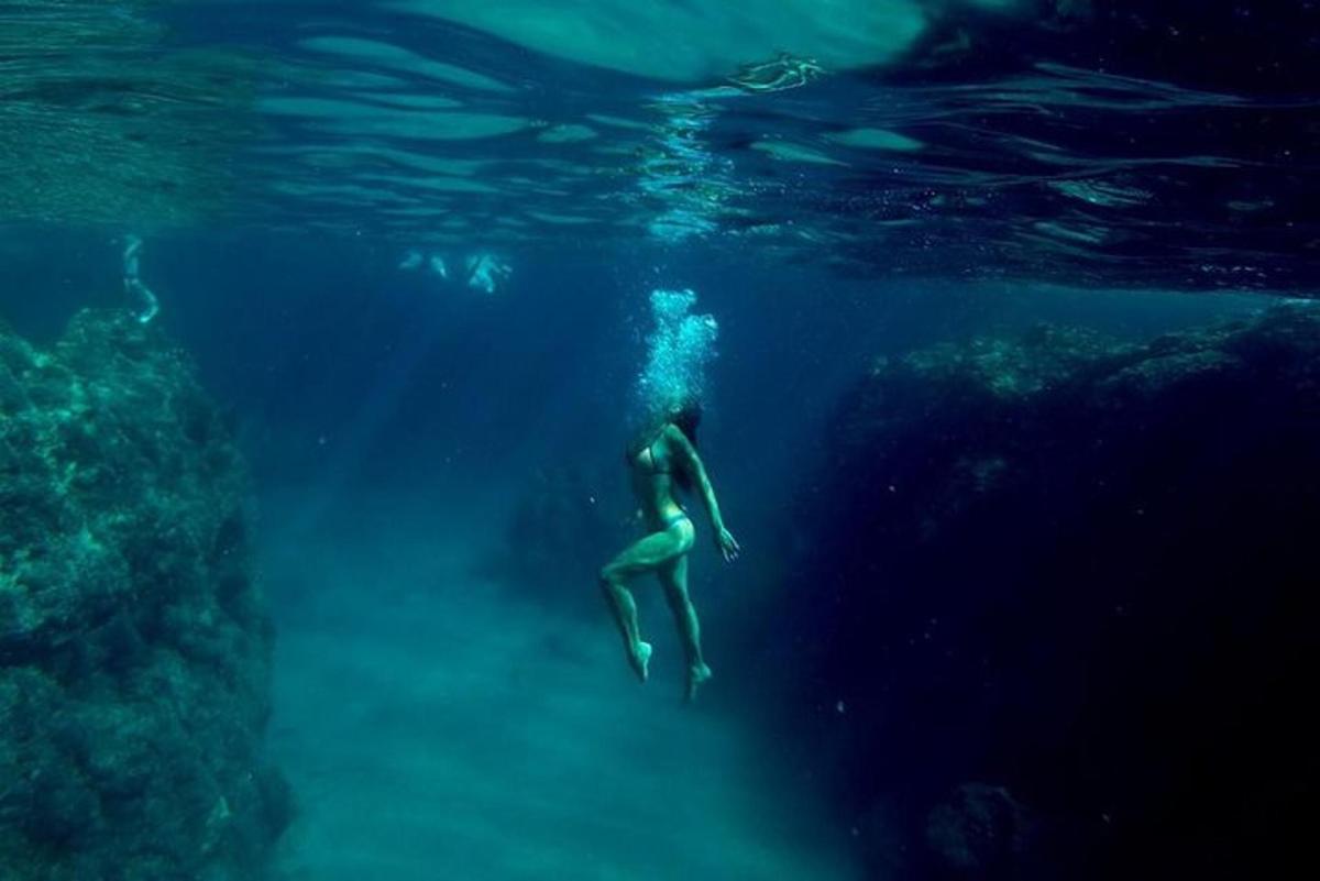seseorang yang berenang di dalam air di lautan