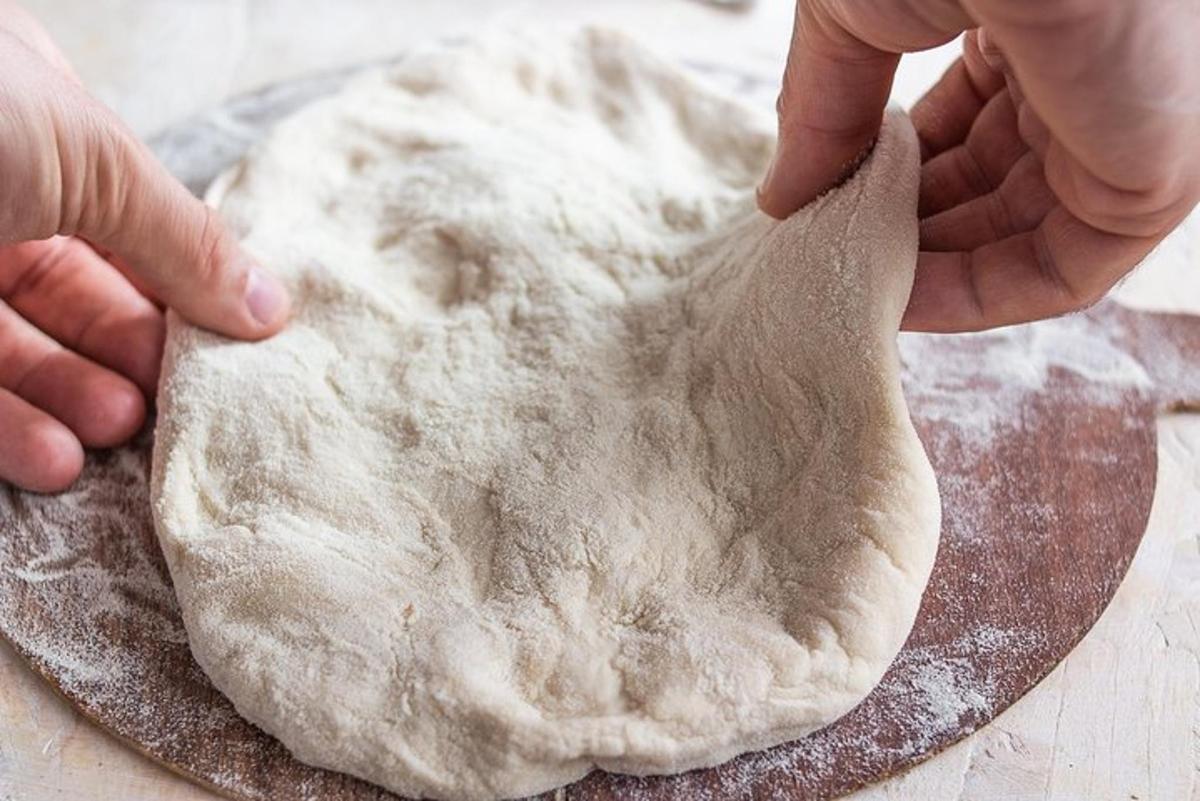 inimene sõtkub laual tainast