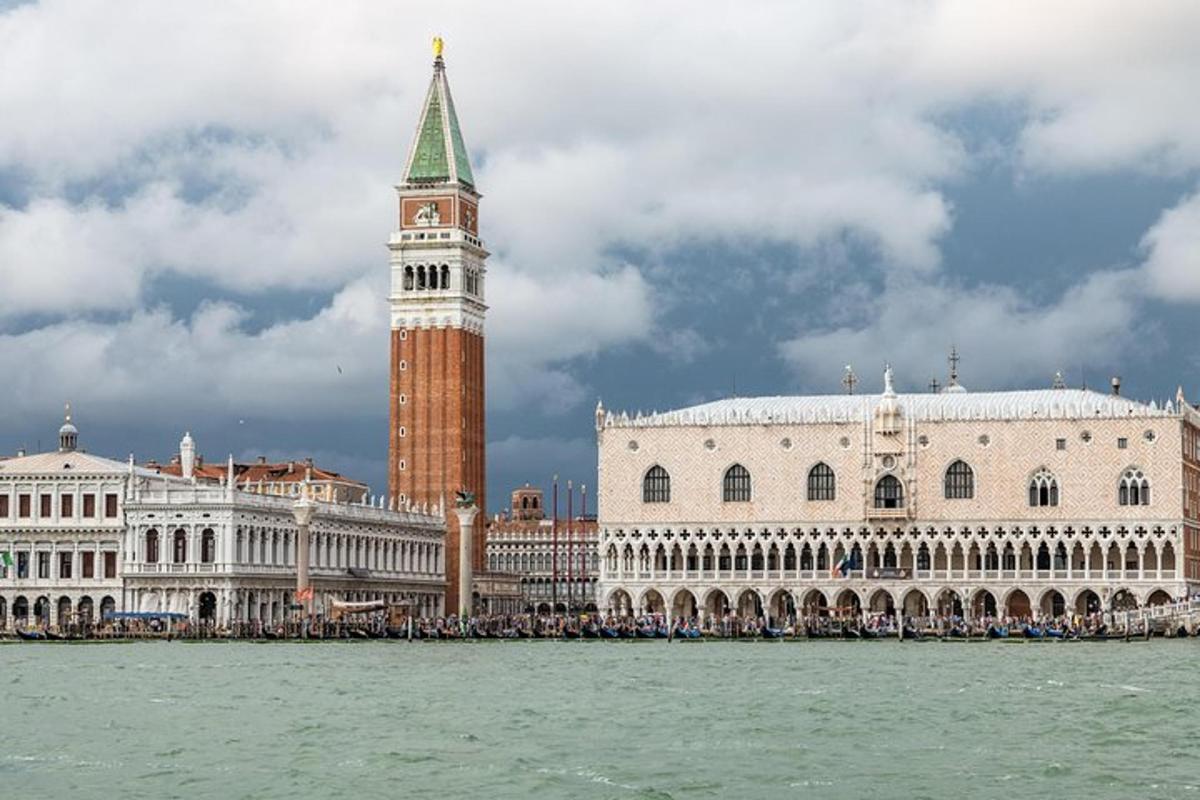 un grande edificio con una torre dell'orologio accanto all'acqua