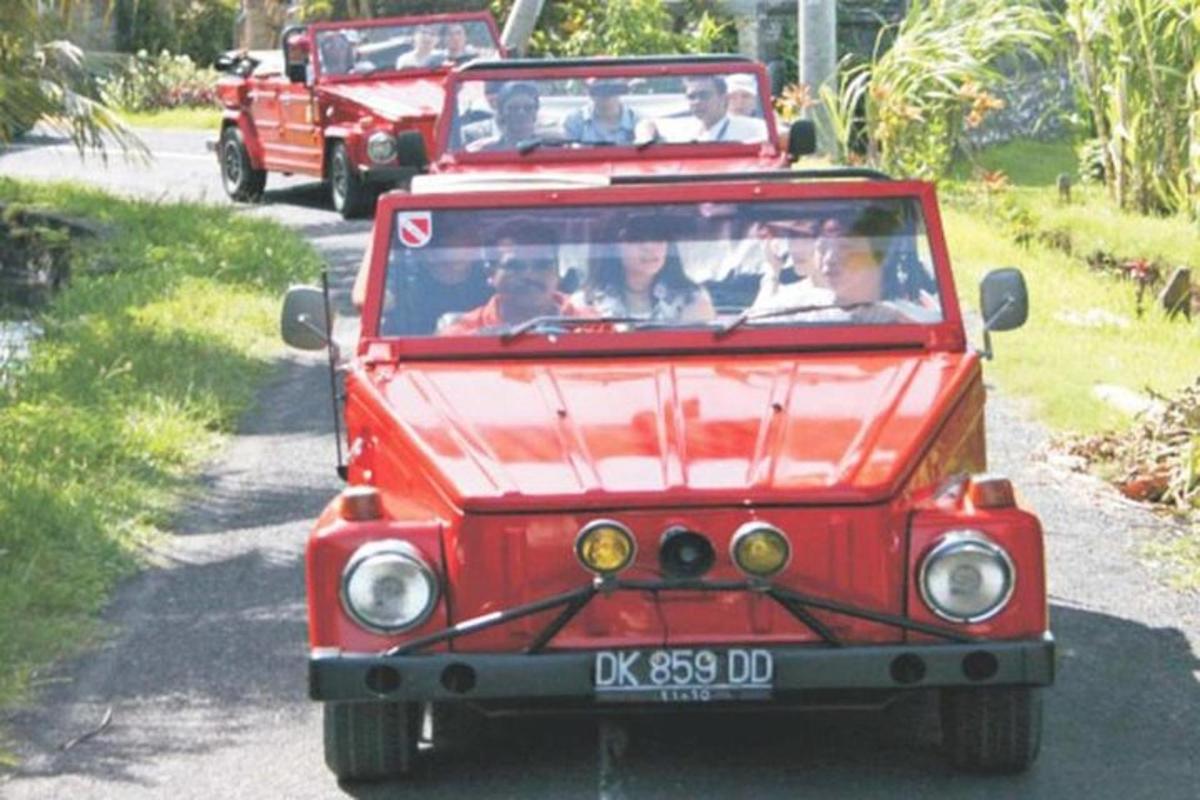 a group of people riding in a red jeep