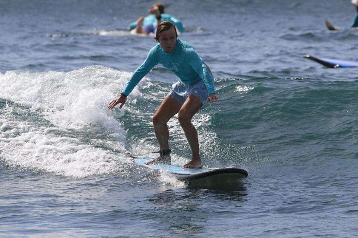 um menino pegando uma onda em uma prancha de surfe no oceano