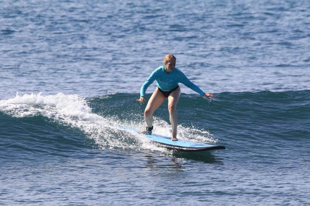 ženska, ki jaha val na deski za surfanje v oceanu