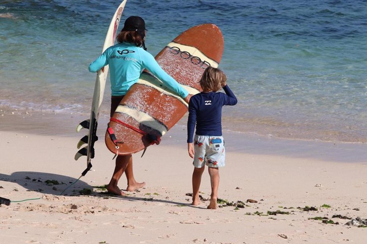 duas pessoas em pé na praia com suas pranchas de surfe