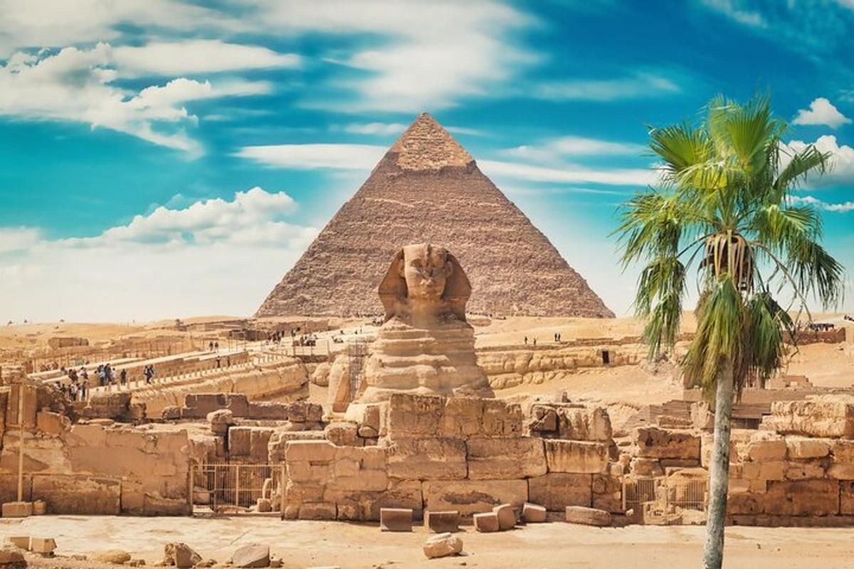 una piramide e una statua di leone davanti a una palma