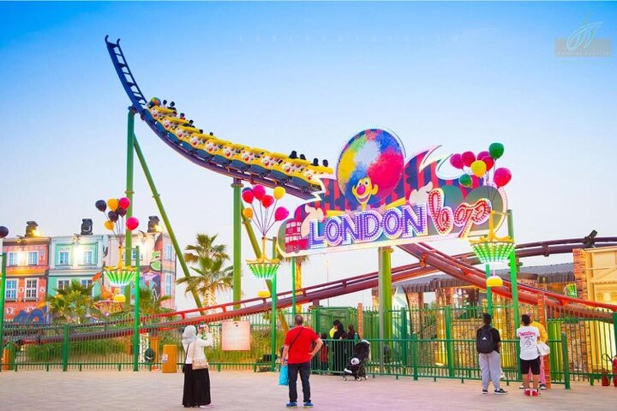 a group of people standing in front of a roller coaster