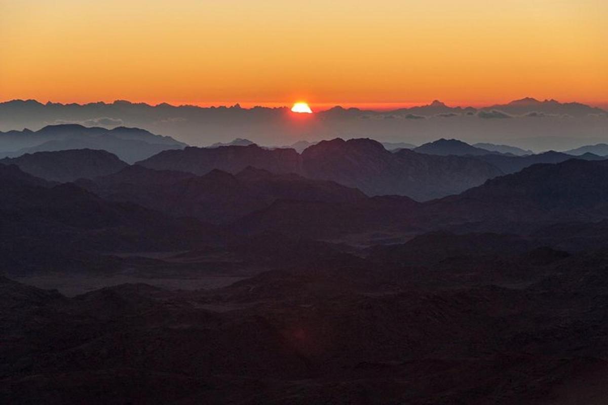 uma vista de uma cadeia de montanhas ao pôr do sol
