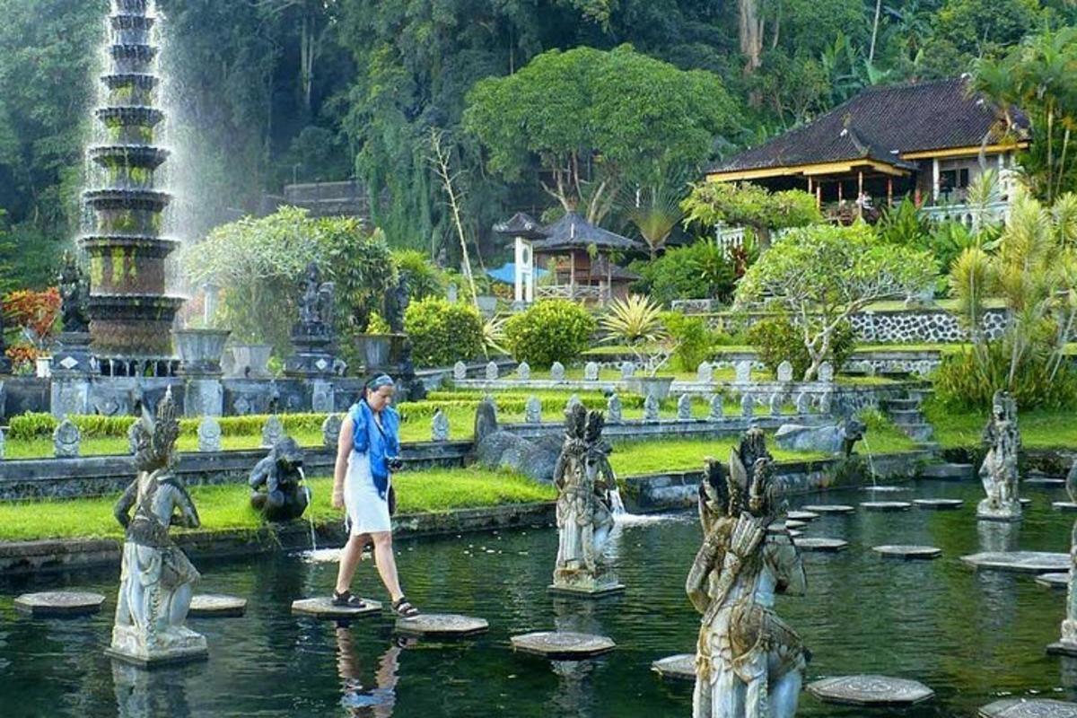 un home caminant per una font en un jardí