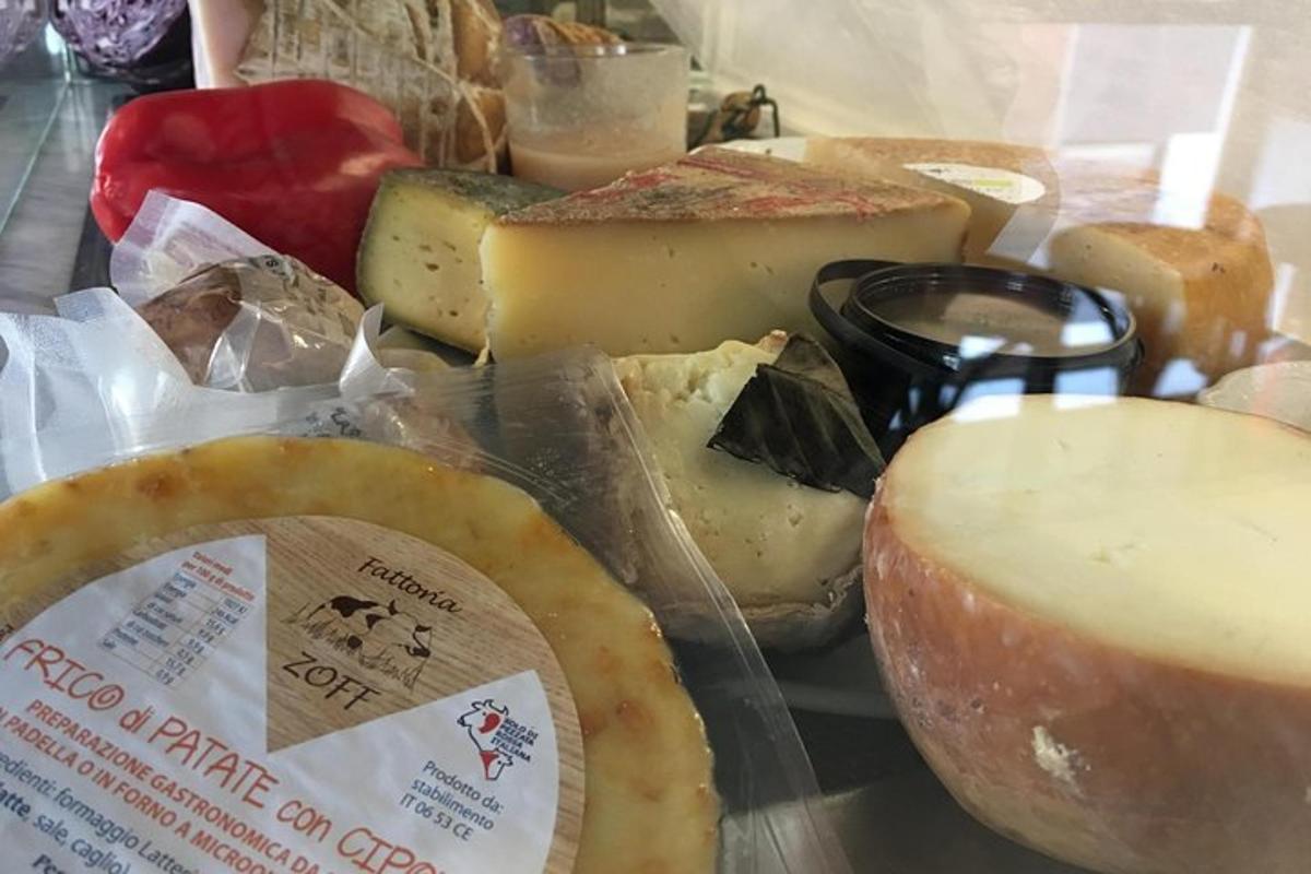 een heleboel kazen en ander voedsel op een tafel