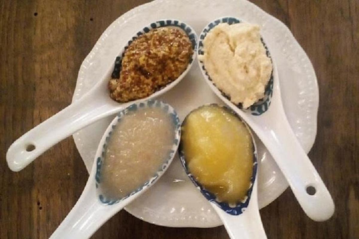 um prato branco com quatro colheres sobre uma mesa