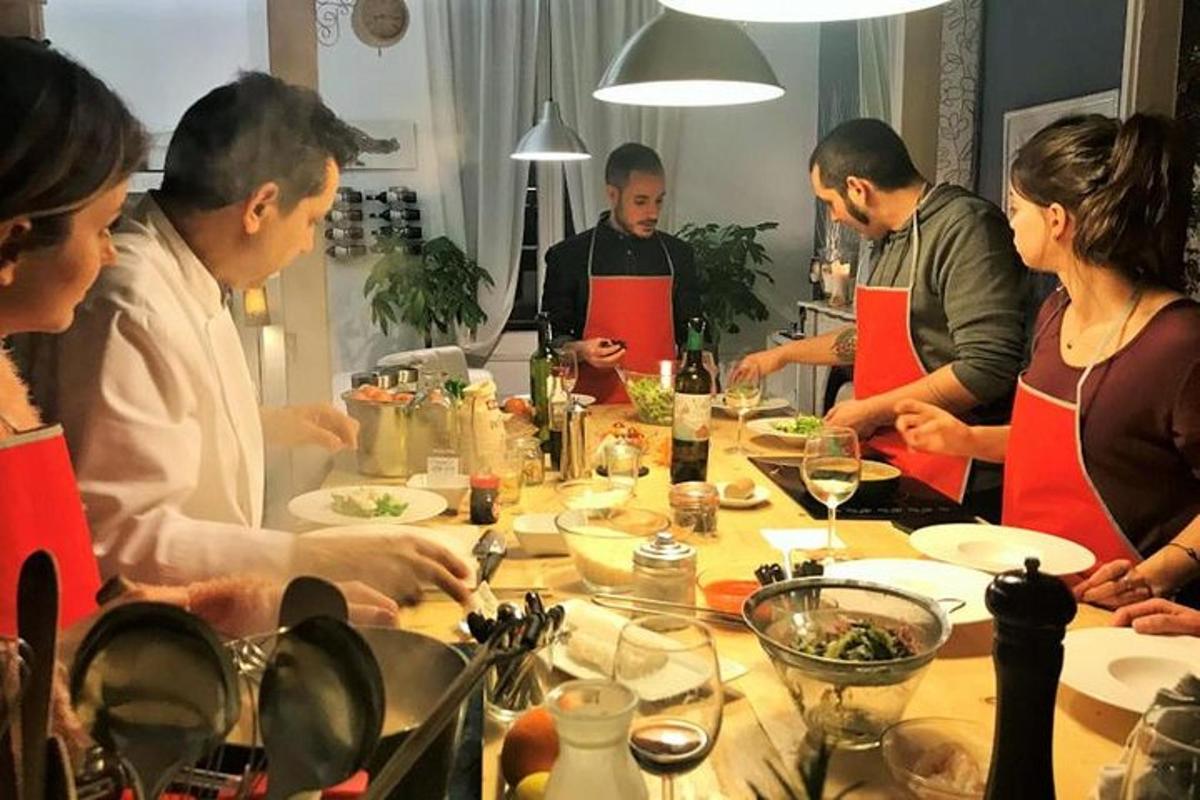 skupina ljudi, ki stojijo okoli mize s hrano