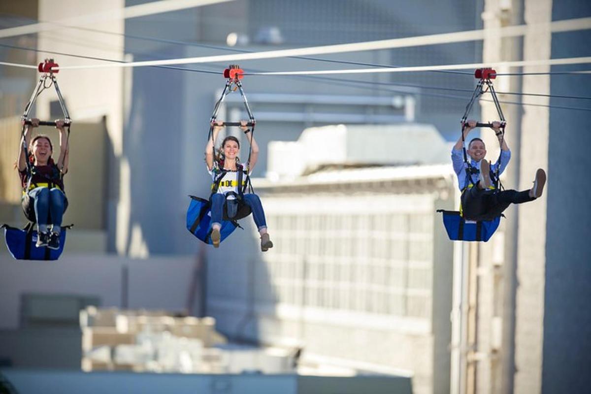three people are riding on a zip line