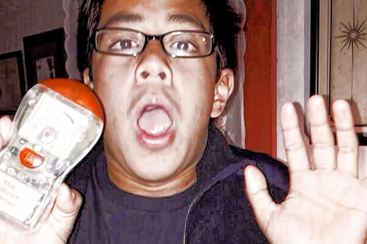 a man holding an orange and a cell phone