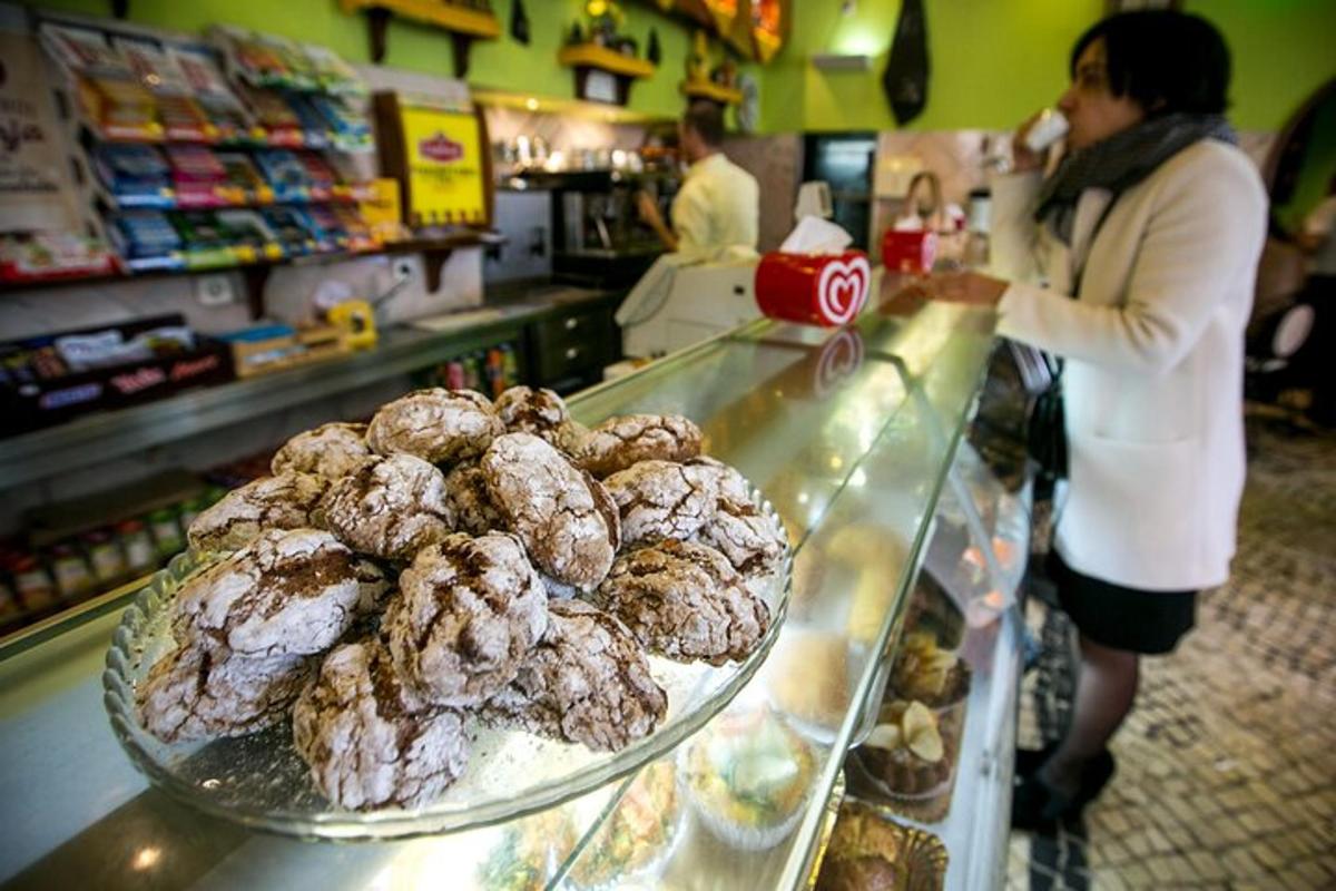 uma mulher em pé atrás de um balcão em uma loja de donuts