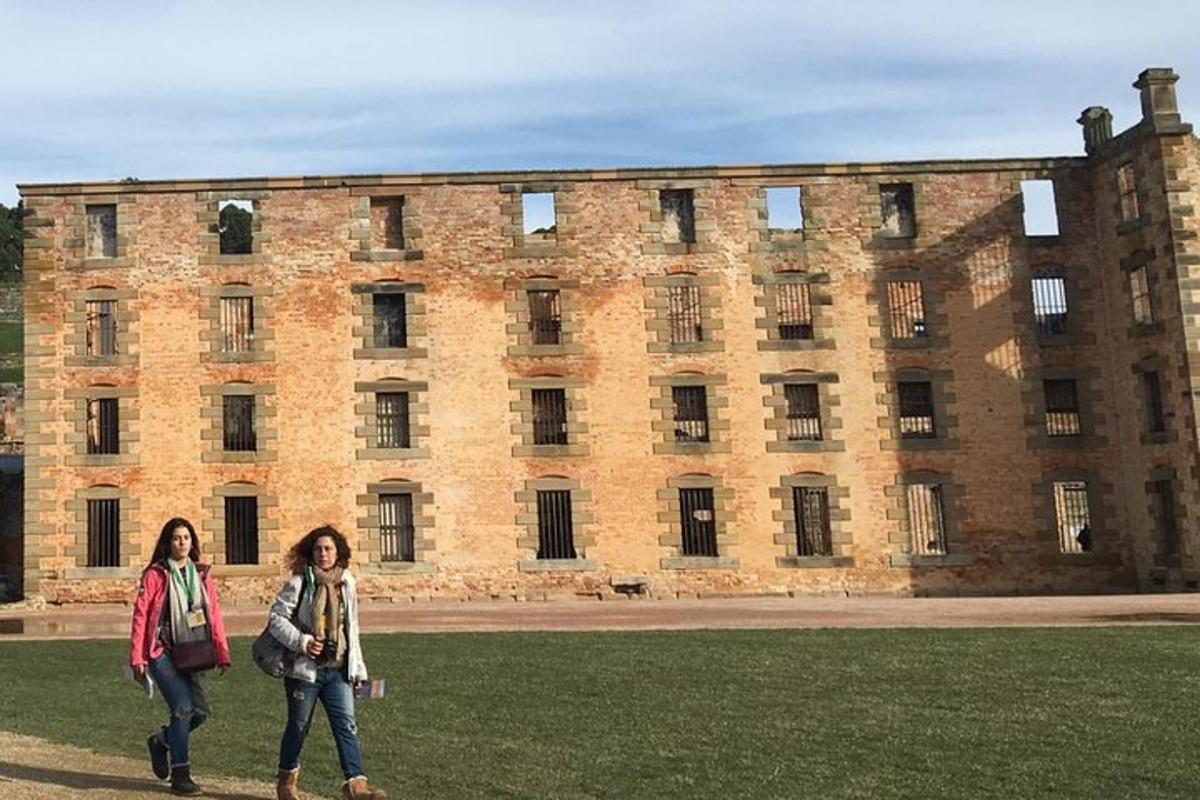 two women walking in front of a large brick building
