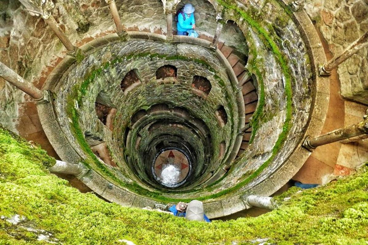 una scala a chiocciola con due persone in cima