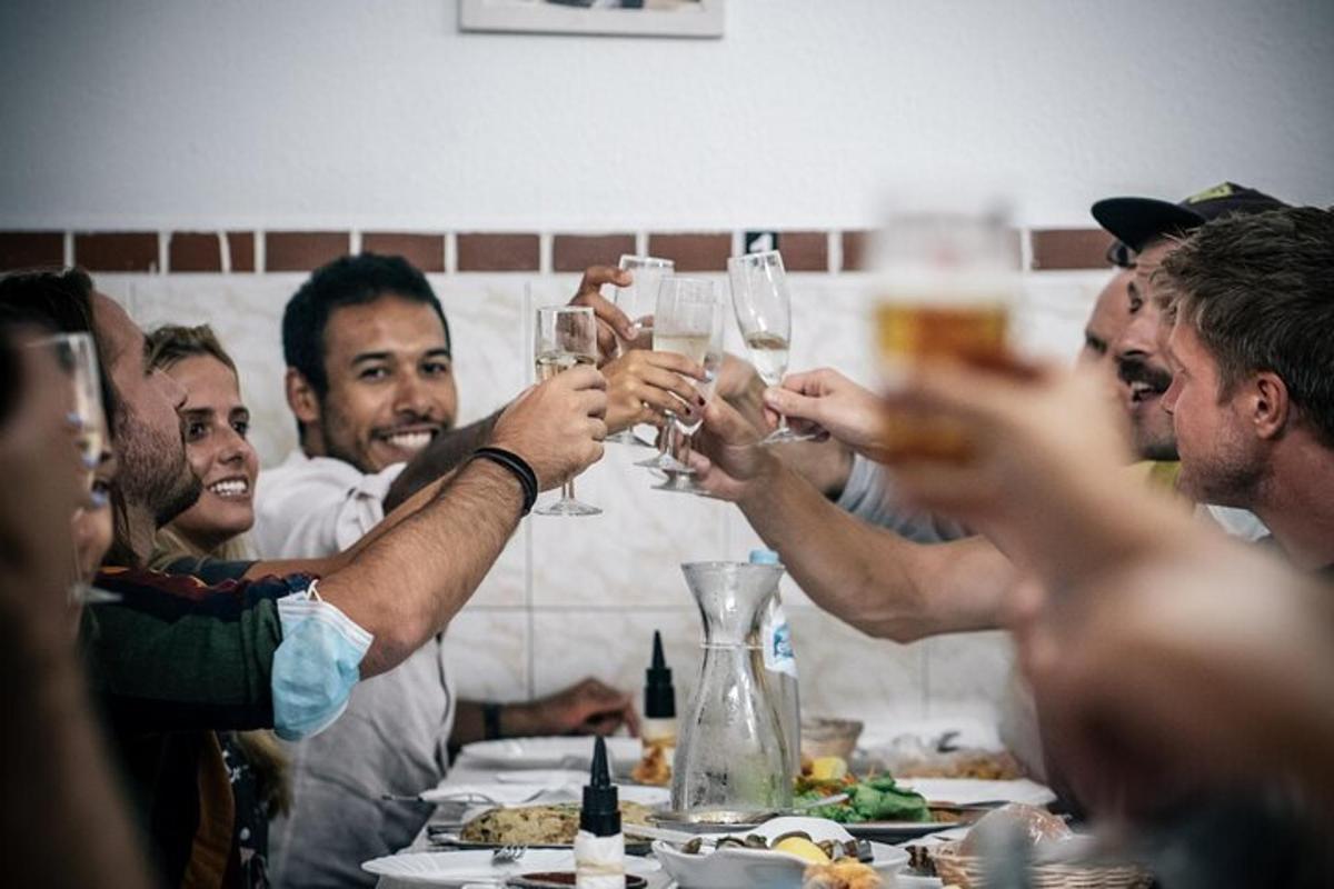 a group of people holding up wine glasses at a table