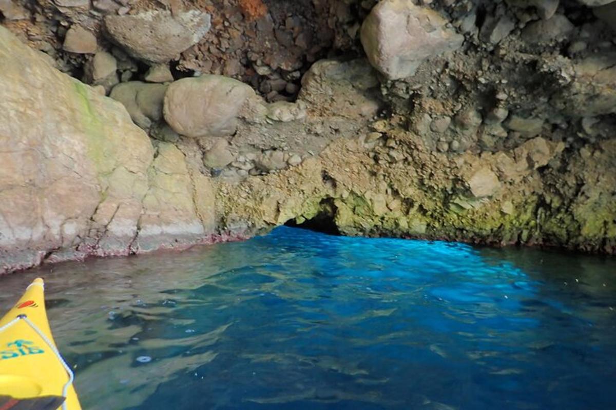 um caiaque em uma caverna com água azul