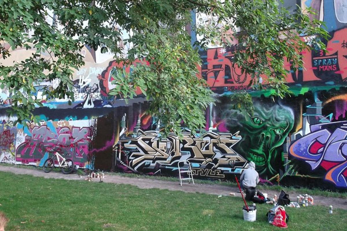 una persona seduta davanti a un muro con graffiti