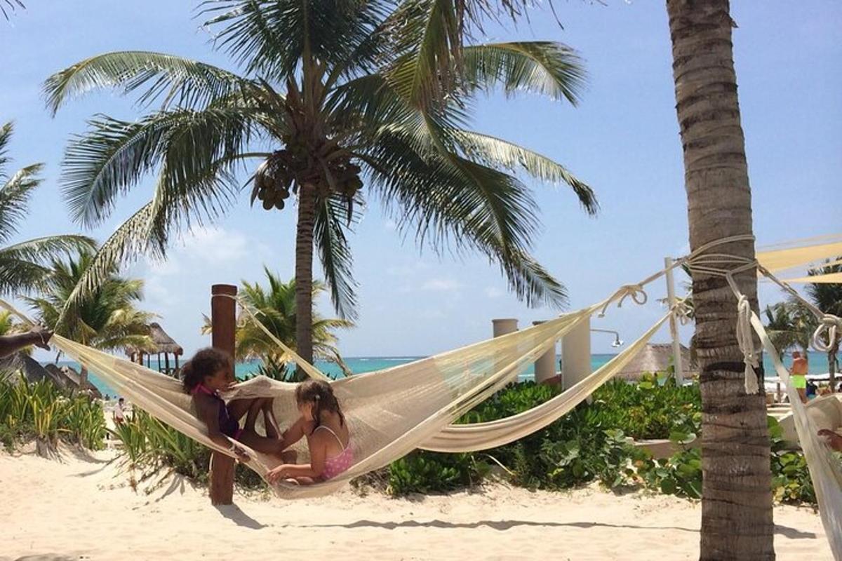 two girls sitting in a hammock on the beach