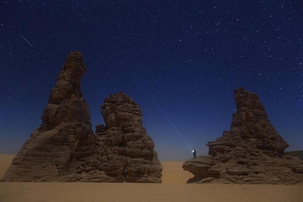 una persona in piedi di fronte ad alcune rocce nel deserto