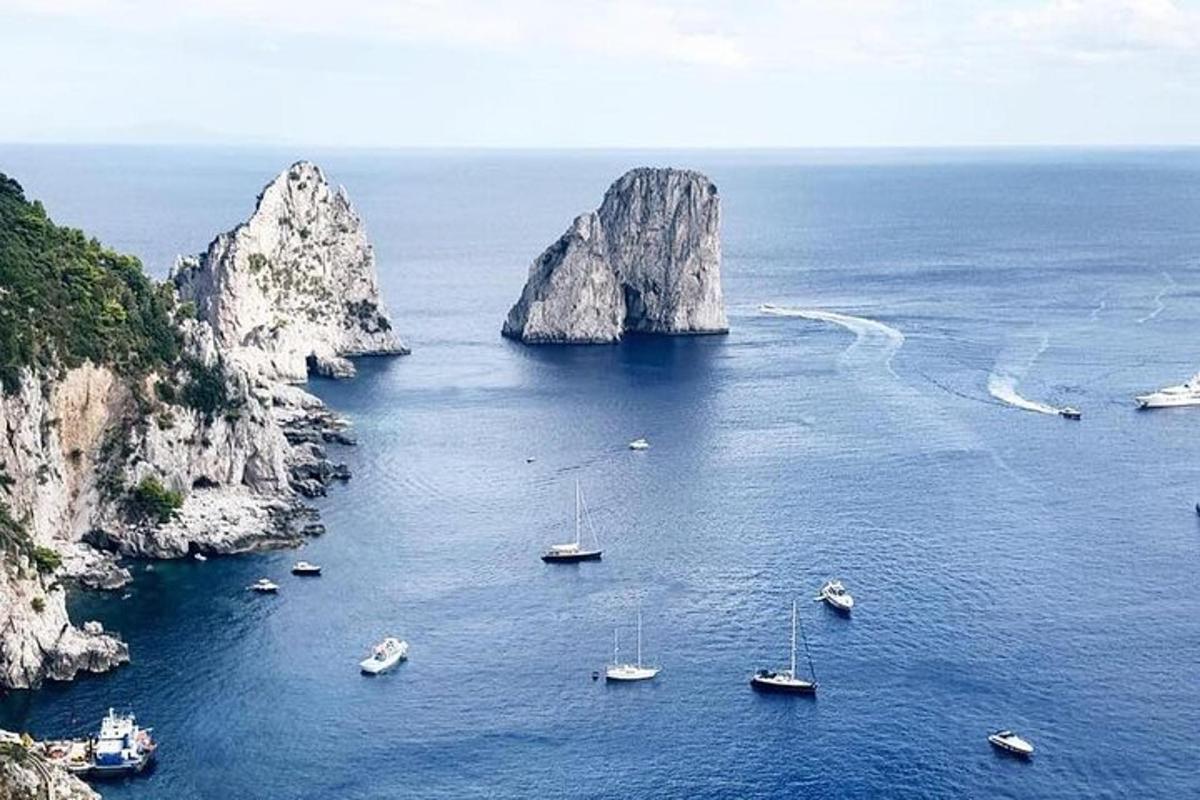 Un grupo de barcos en el agua cerca de unas rocas.