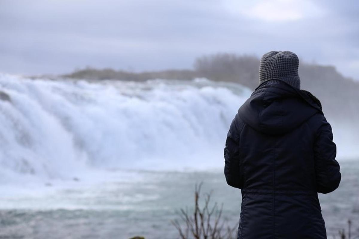 seseorang berdiri di depan air terjun