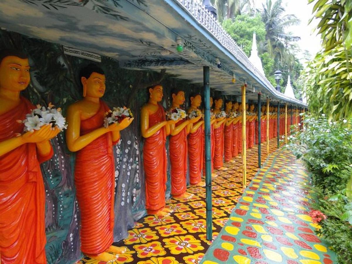 một hàng tượng các nhà sư mặc áo choàng màu cam