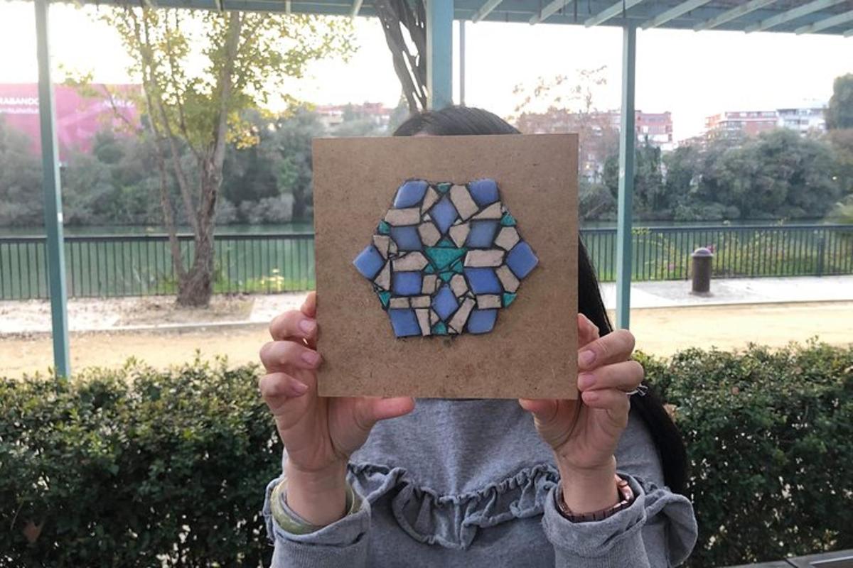 a person holding up a box with a mosaic