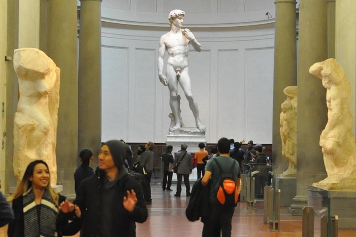 folk som går i et museum med en statue i bakgrunnen