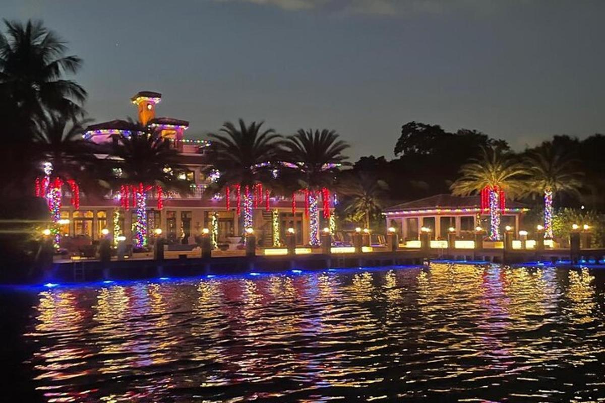 a building with christmas lights on the water at night