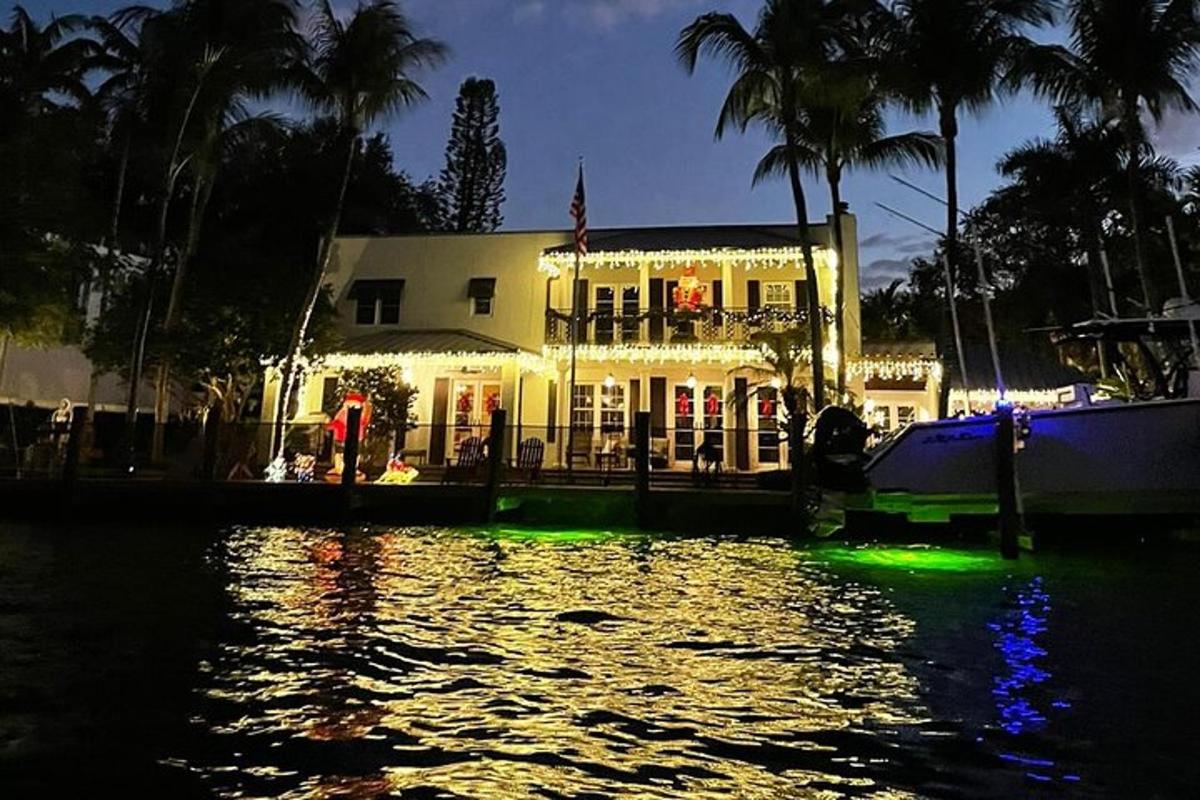a house with green lights on the water at night