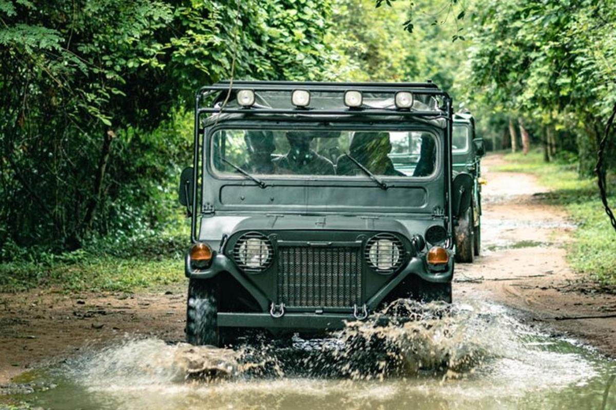 ein grüner Jeep, der durch eine schlammige Straße fährt