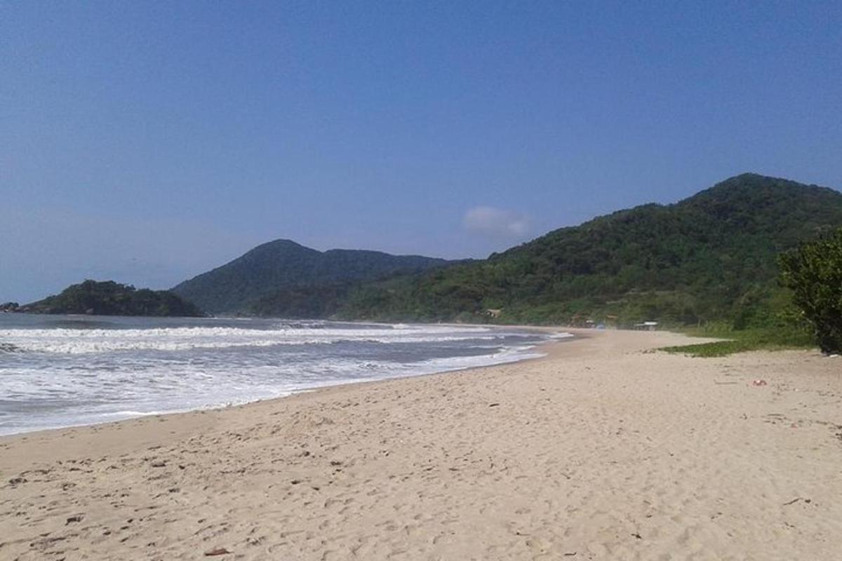 a sandy beach with mountains in the background