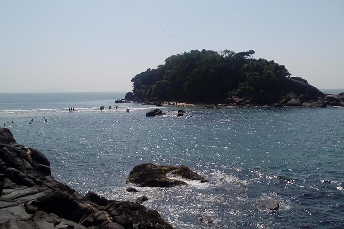 a group of people on a beach near the water
