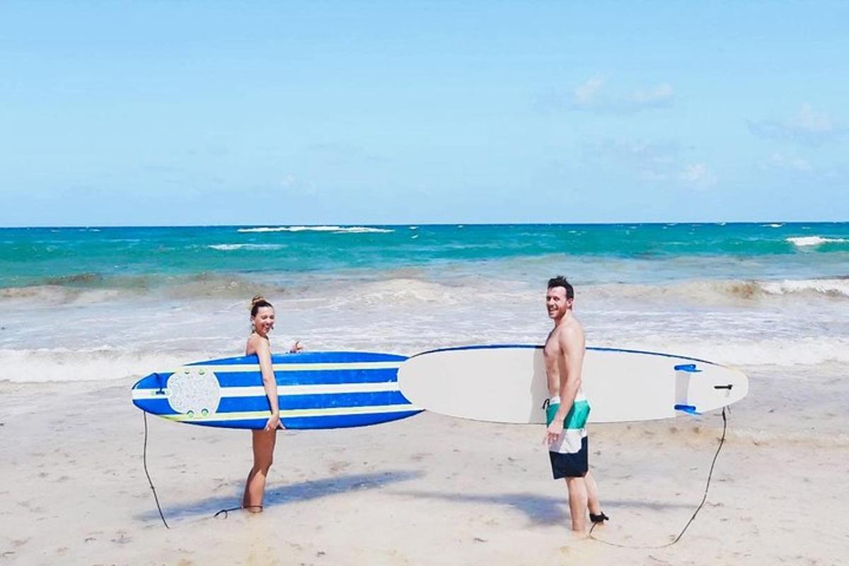 two people standing on the beach with their surfboards