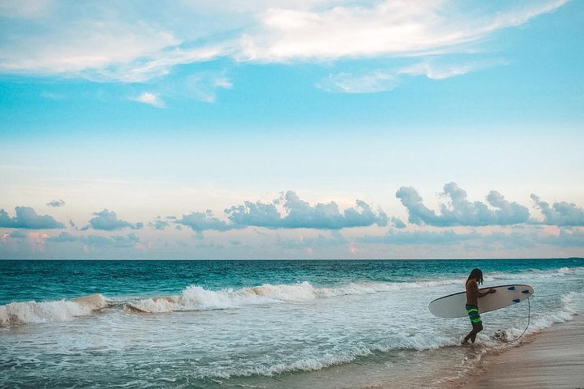 a person walking on the beach with a surfboard