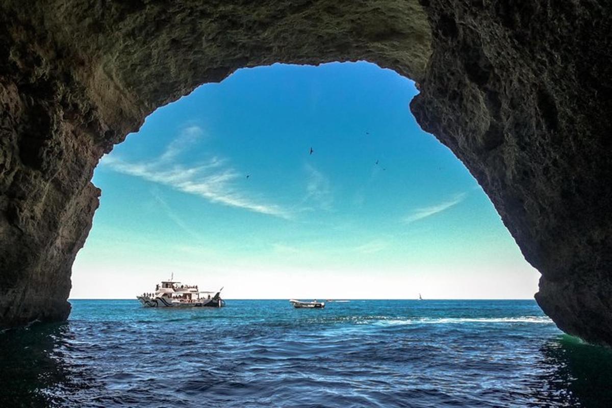 a cave in the ocean with two boats in the water