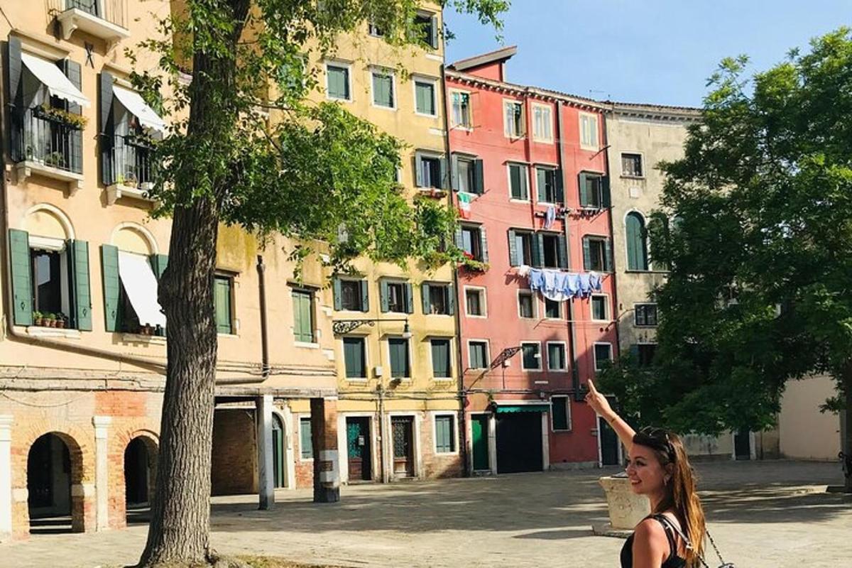 ženska, ki stoji ob drevesu z roko v zraku