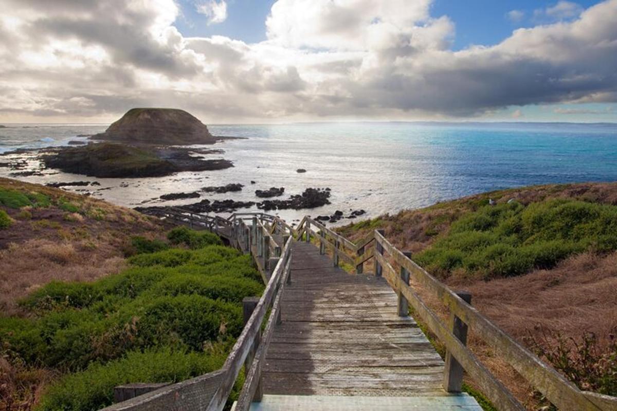 a staircase leading down to a beach with a view of the ocean