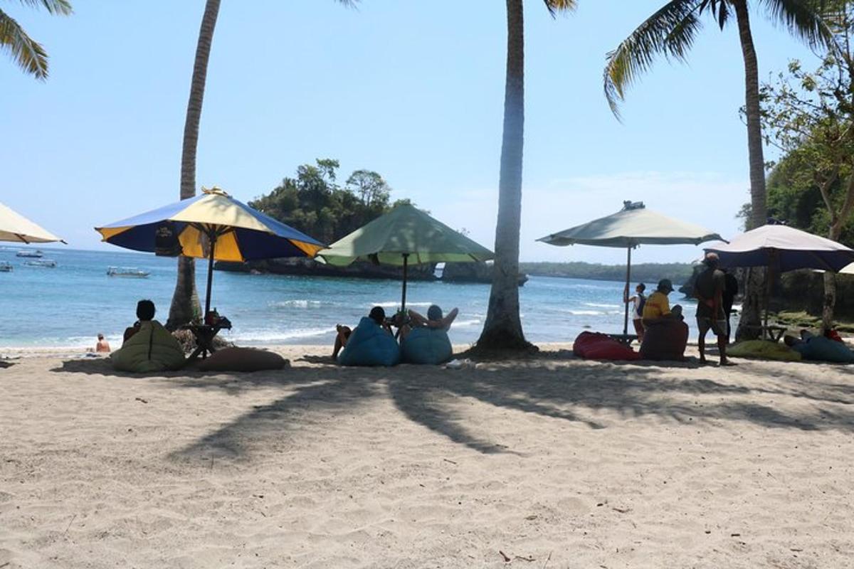a group of people sitting on the beach under umbrellas