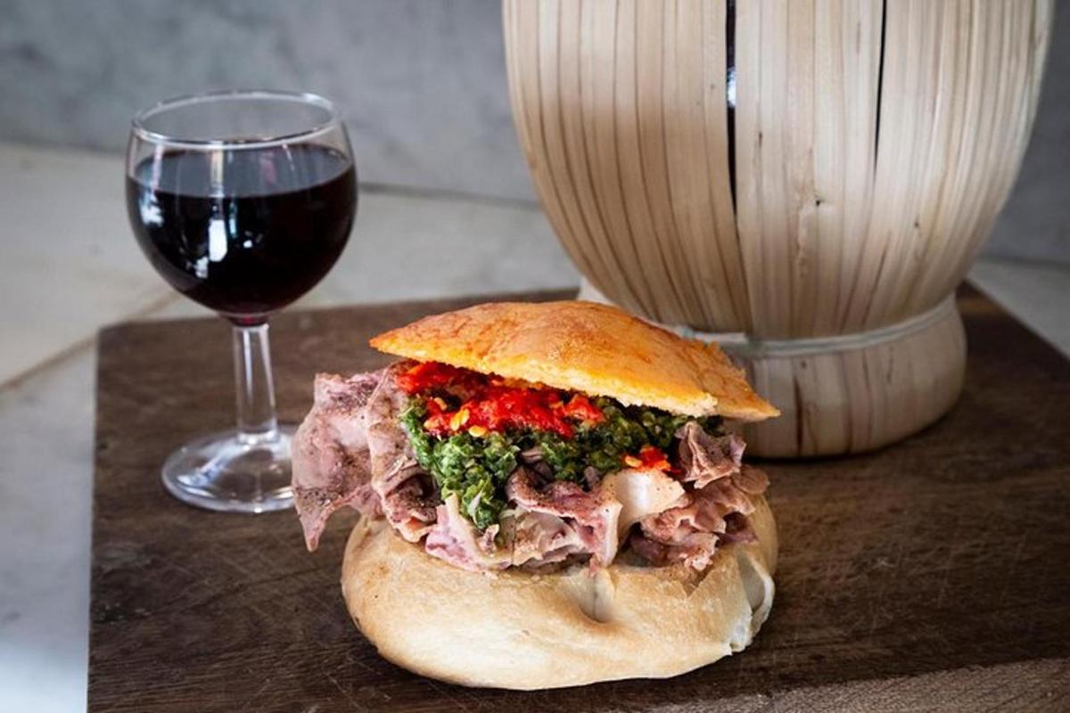 a sandwich sitting next to a glass of wine