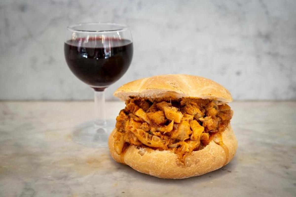 a sandwich next to a glass of wine